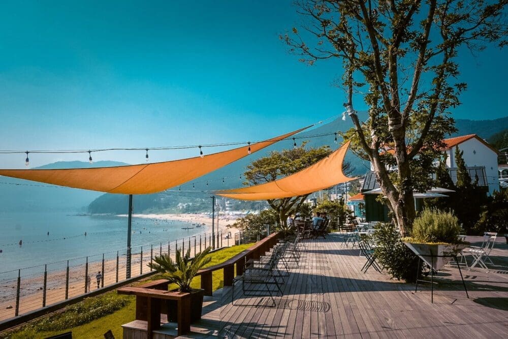 17 Spectacular Beaches in Korea to Beat the Summer Heat 13 beaches in korea | view of gujora beach on geoje island from oedo nursery cafe